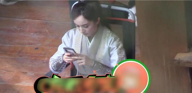 杨幂拍摄现场心情沮丧，神色凝重看手机对助理