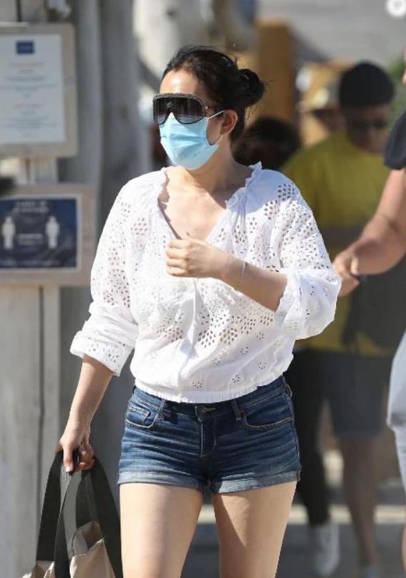 巩俐无意露肚脐太尴尬！携71岁老公沙滩漫步，游