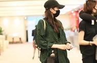 Guan Xiaotong comes to the airport, wear black to grow sleeve jacket to build pants of stripe broad