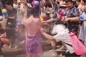 女子泼水节成为众男子围观焦点，撕雨衣狂欢引热议！