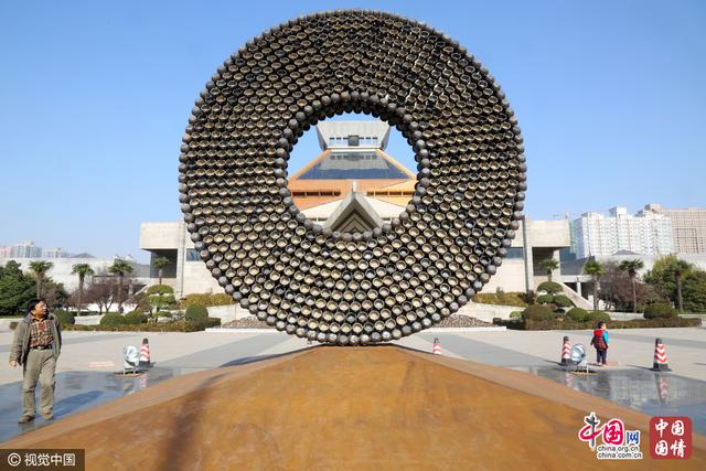 郑州街头现巨型“铜钱”引围观 用2500多个砂锅组成