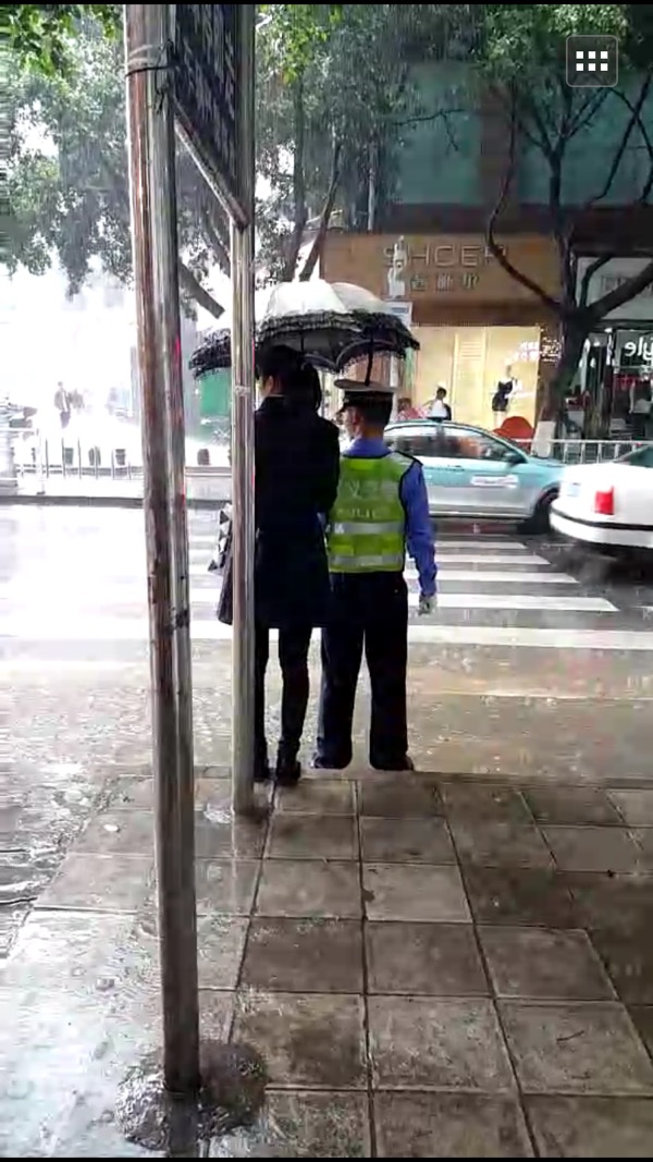 温暖！交警大雨中指挥交通 兴义“撑伞姐”为他挡雨