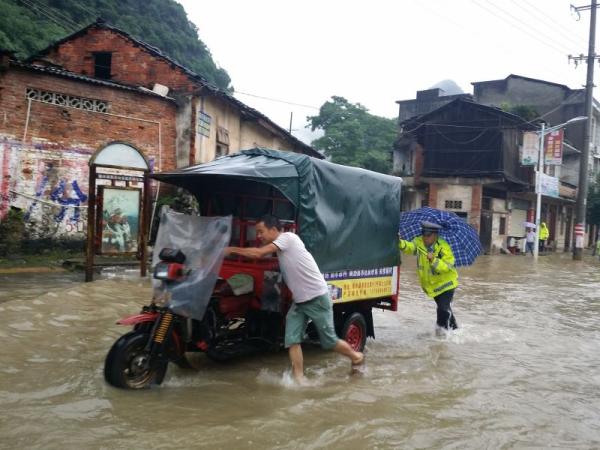 融水暴雨导致县城积水 交警背老人淌水过街