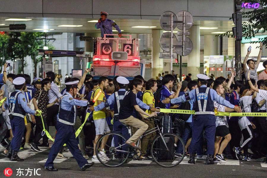 日本世界杯球迷(日本球迷街头狂欢庆祝第三次世界杯小组出线 大量警力维持秩序)