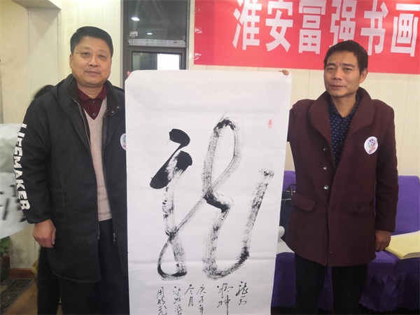 淮安：企业、画院在“志愿者日”携手开展书画赠百姓活动