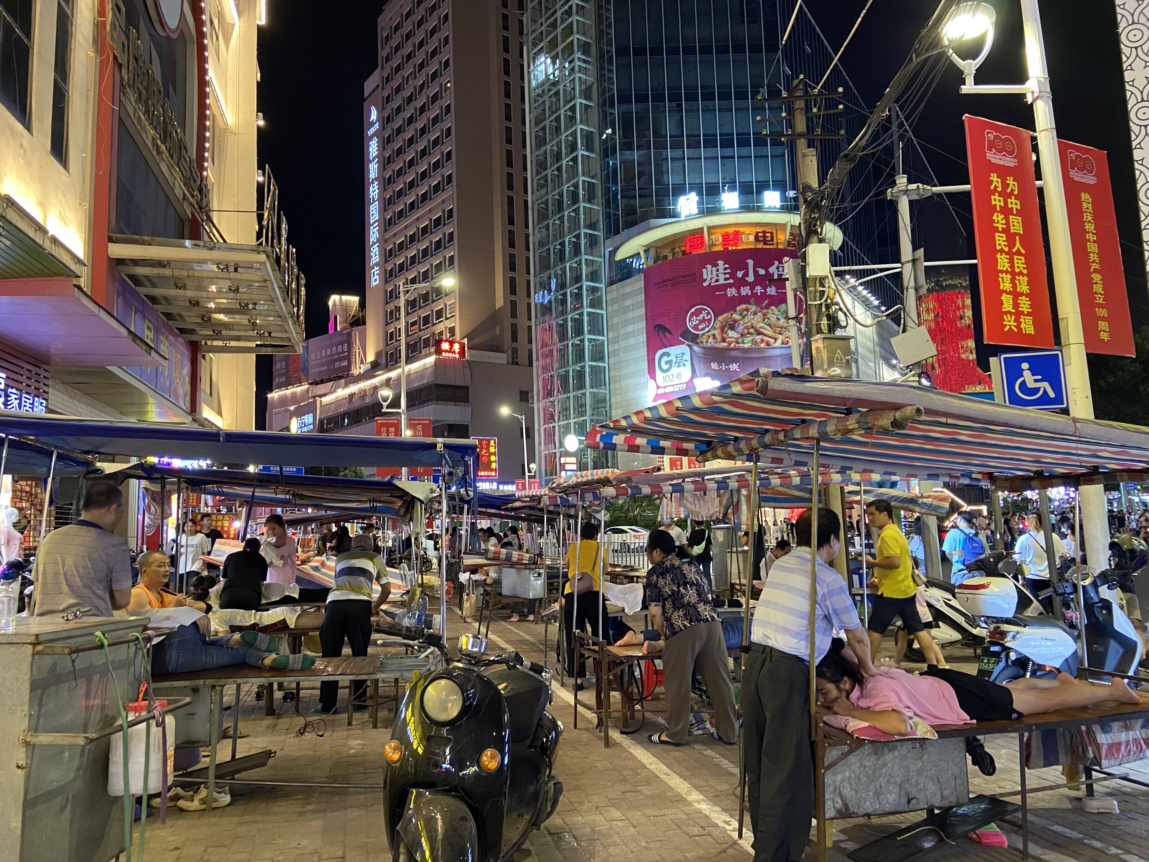 按摩摊附近就是繁华的街市.