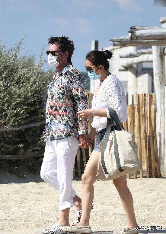 巩俐与71岁老公十指紧扣逛街，诡异地出现了第三