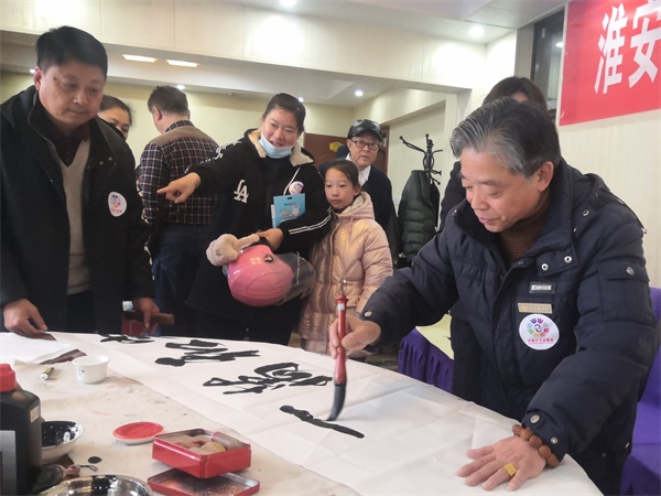 淮安：企业、画院在“志愿者日”携手开展书画赠百姓活动