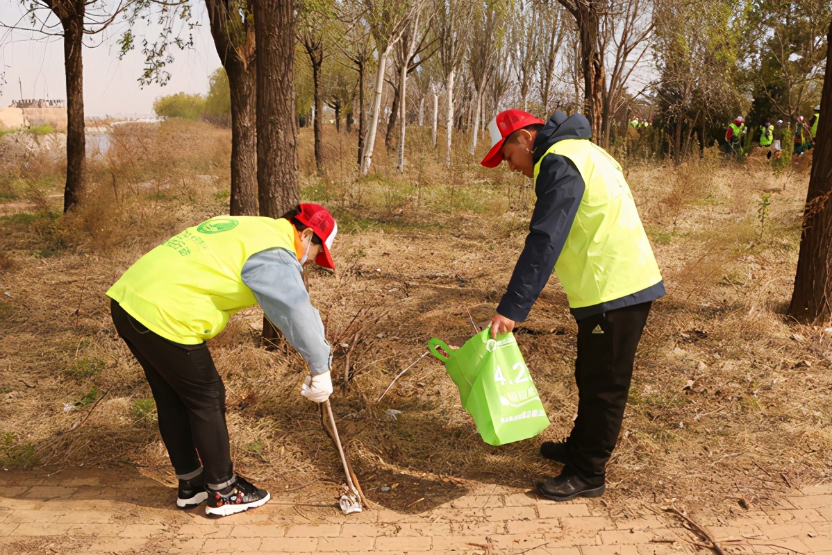 迎接世界地球日营口环保志愿者在入海口捡拾垃圾