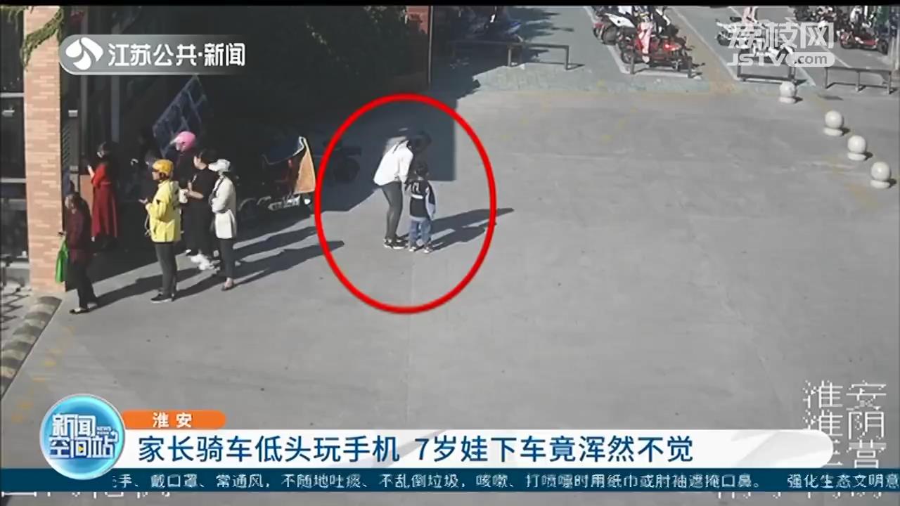家长一边骑车一边玩手机 7岁娃下车浑然不觉
