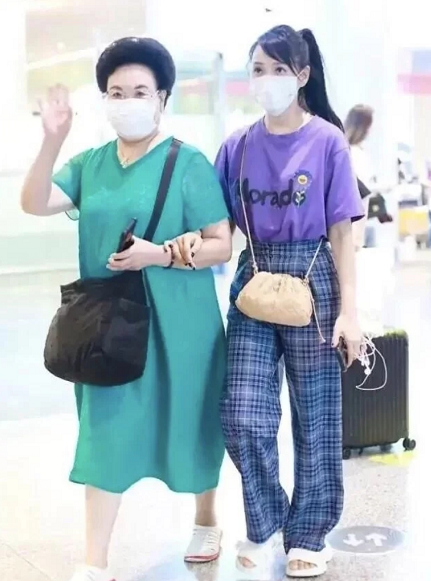 伊能静陪婆婆走机场，扎斜马尾配粉包真显嫩，比一旁秦昊看着还小