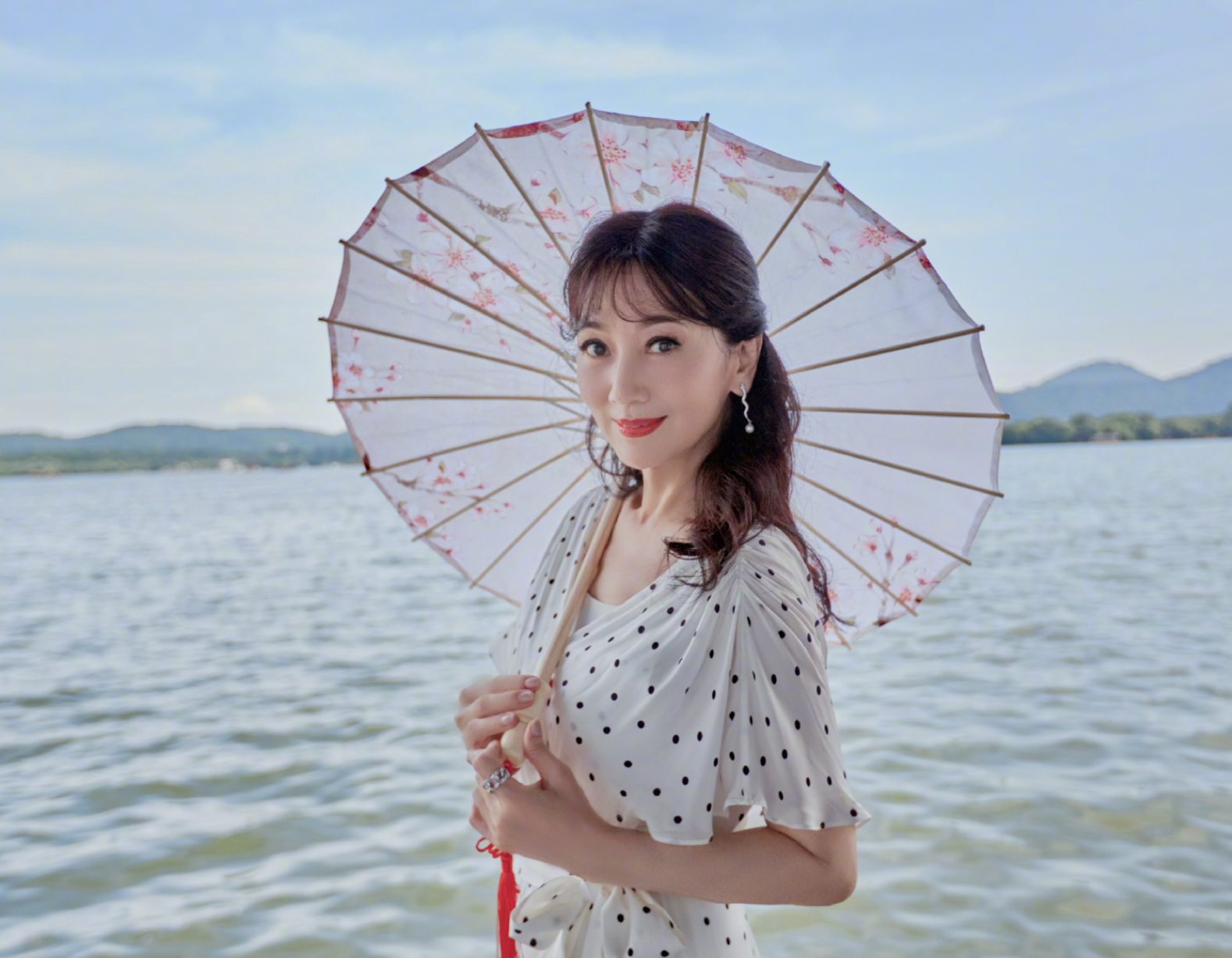 赵雅芝时隔29年西湖边撑伞漫步，波点裙配卷发腰肢纤细，哪像66岁
