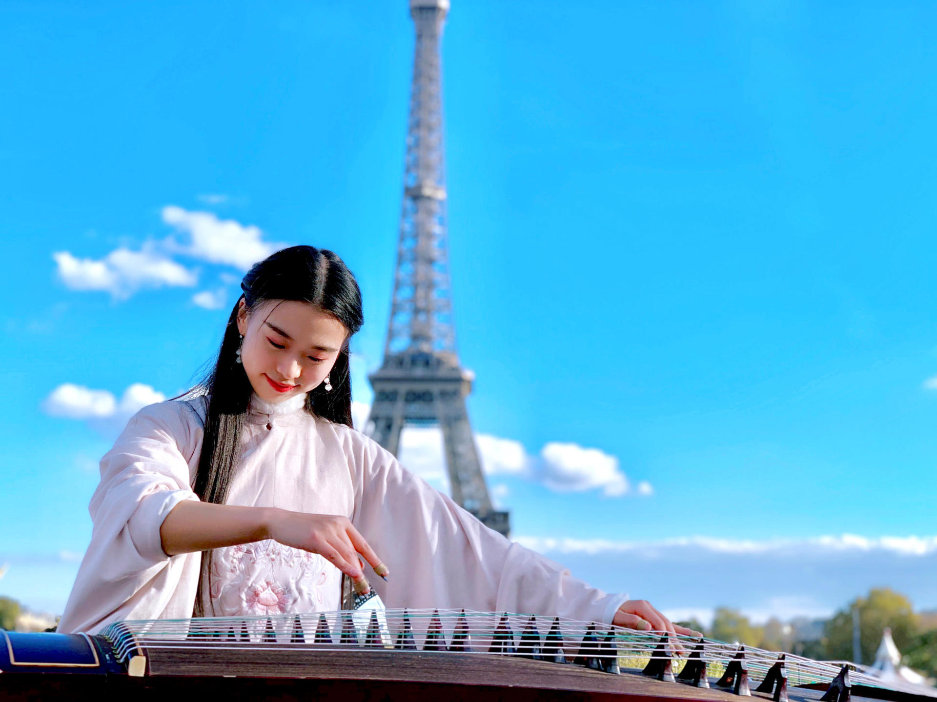 抖音账号@碰碰彭碰碰弹古筝,中国女留学生在法国街头“天外飞仙”表演