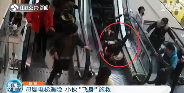 母亲推婴儿车上扶梯摔倒 小伙飞身施救化险