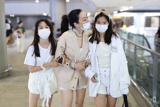 钟丽缇与女儿走机场，针织开衫配白色短裤超洋气，母女美如姐妹花