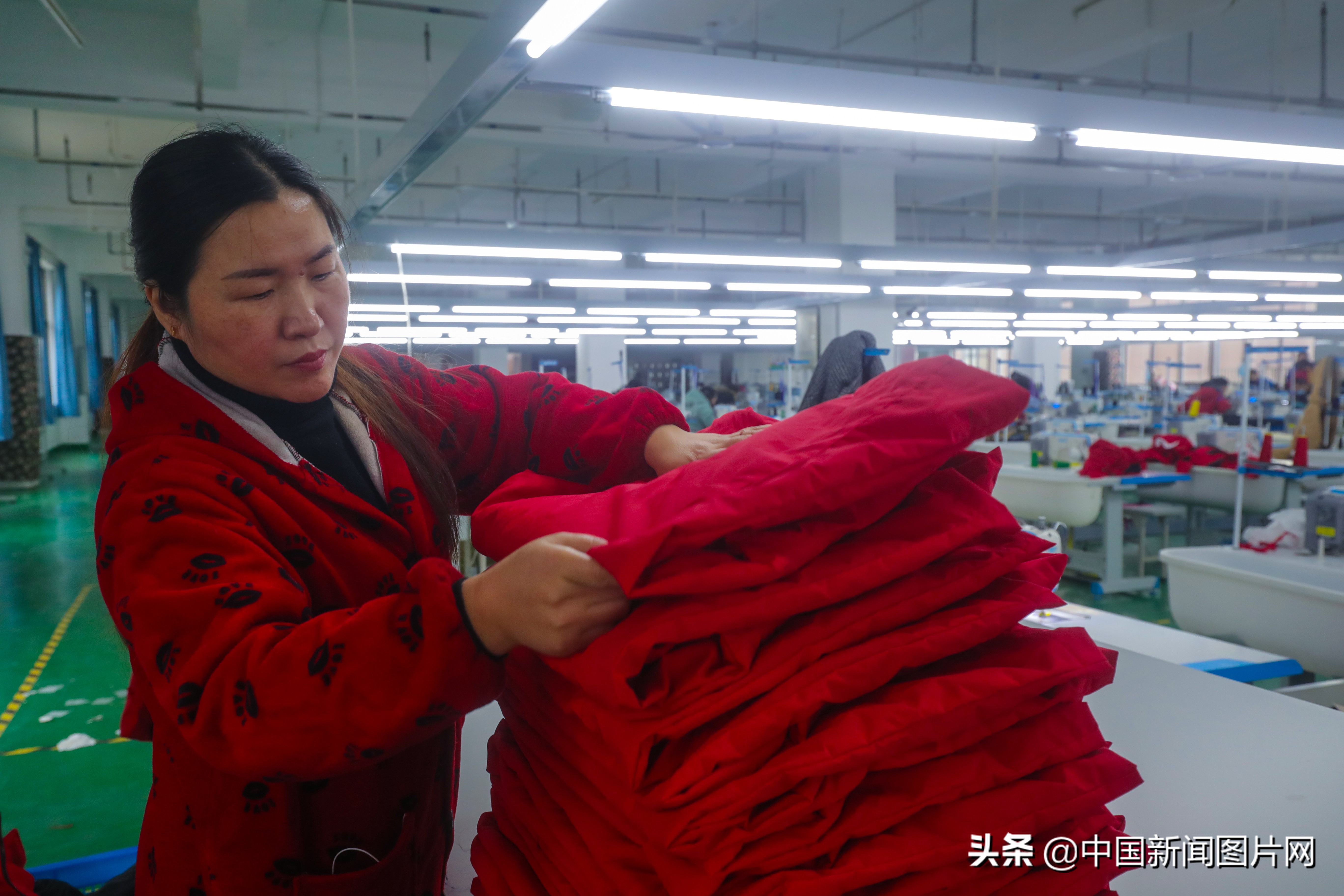 市光山县产业集聚区的良友服饰扶贫车间里工人正在整理客户订单羽绒服