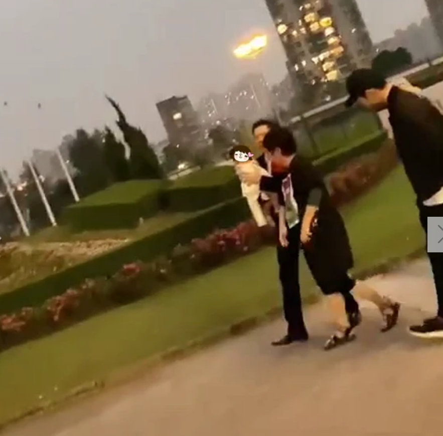 向华强祖孙三代在公园散步，向佐帮郭碧婷拎鞋