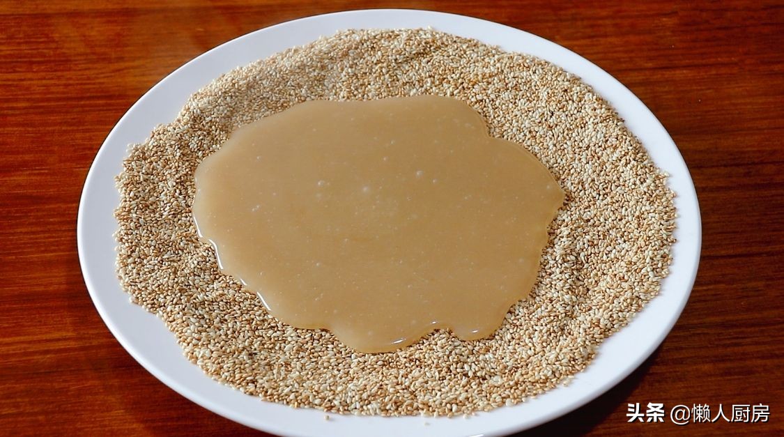 往糯米糊內倒入芝麻，用手壓一壓，就是小時候常吃的美食，有彈性