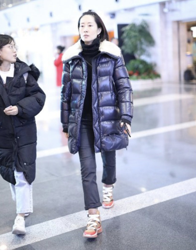 刘敏涛发型有些显头长，素颜现身机场穿羽绒服